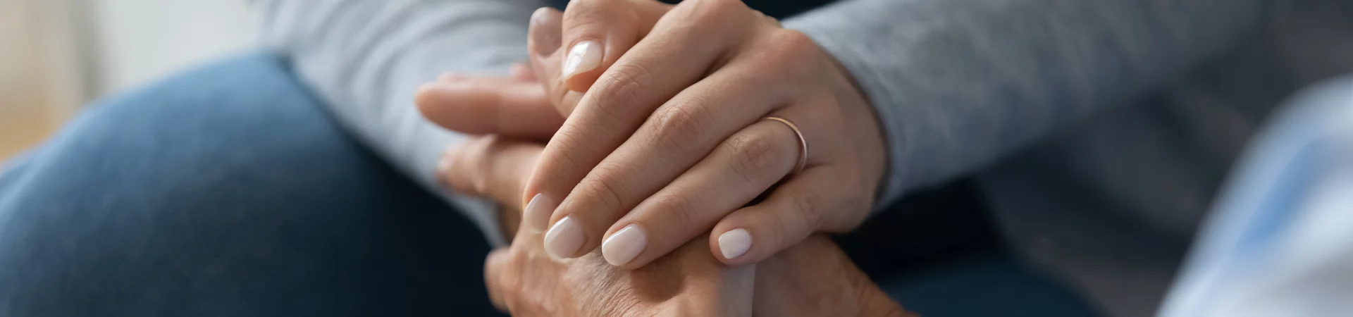 A woman and another woman clasping hands, representing unity and companionship in a heartfelt moment.