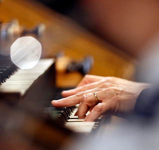 A musician performing on the organ in a church, with intricate details of the building visible in the background. A musician performing on the organ in a church, with intricate details of the building visible in the background.